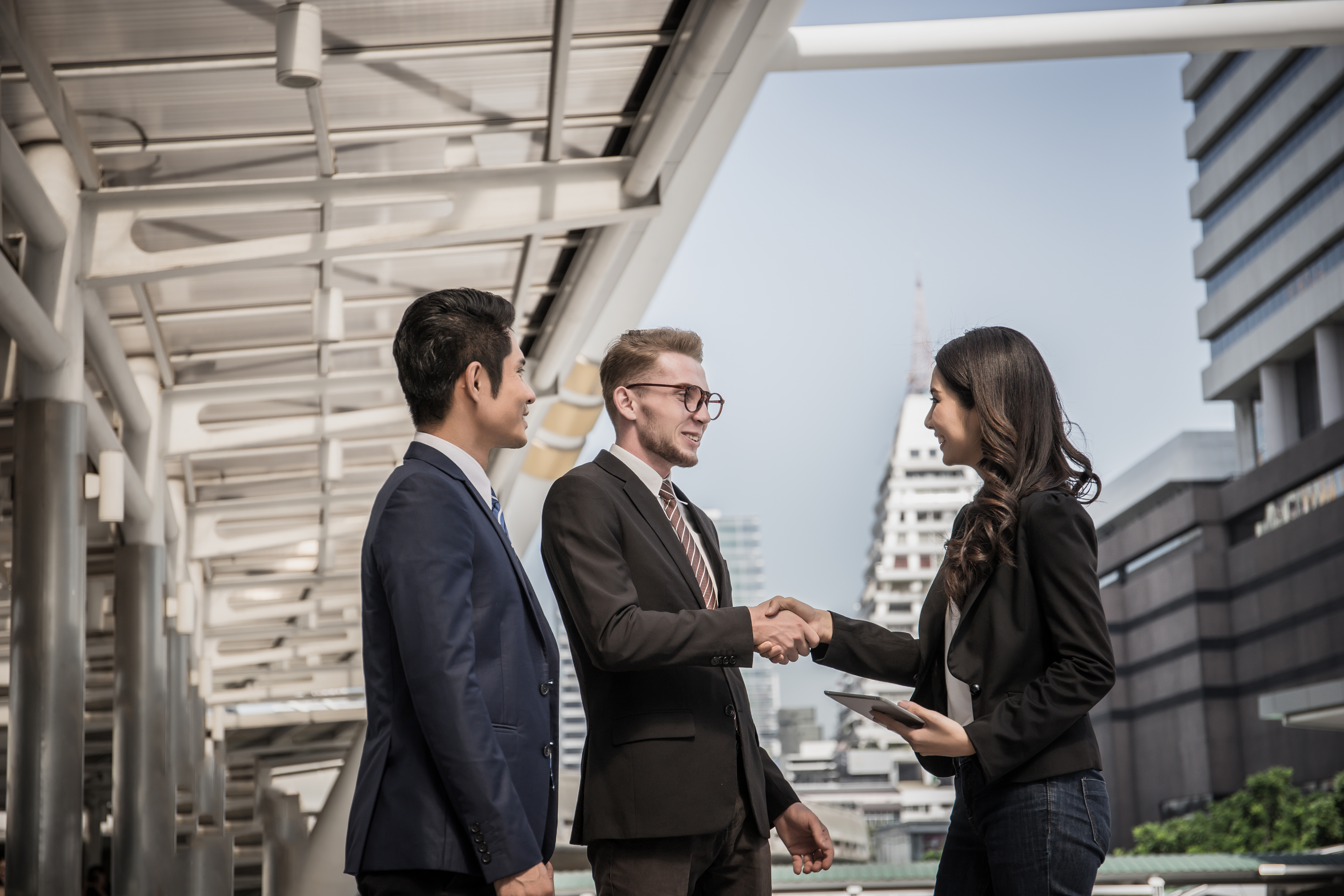Business partner shaking hands and smiling while meeting in fron