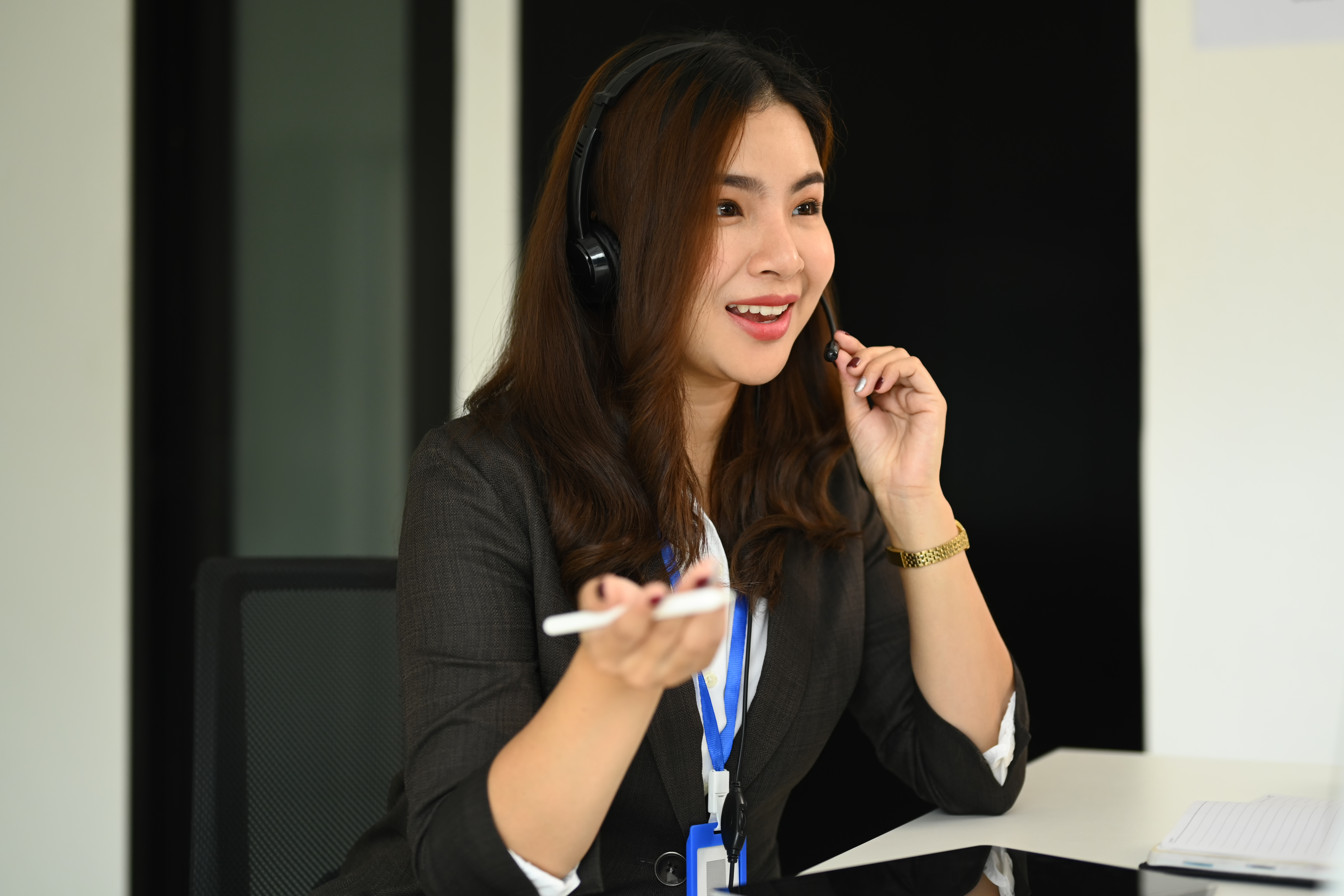 Customer service executive trying to explaining something to client while using headset at call center