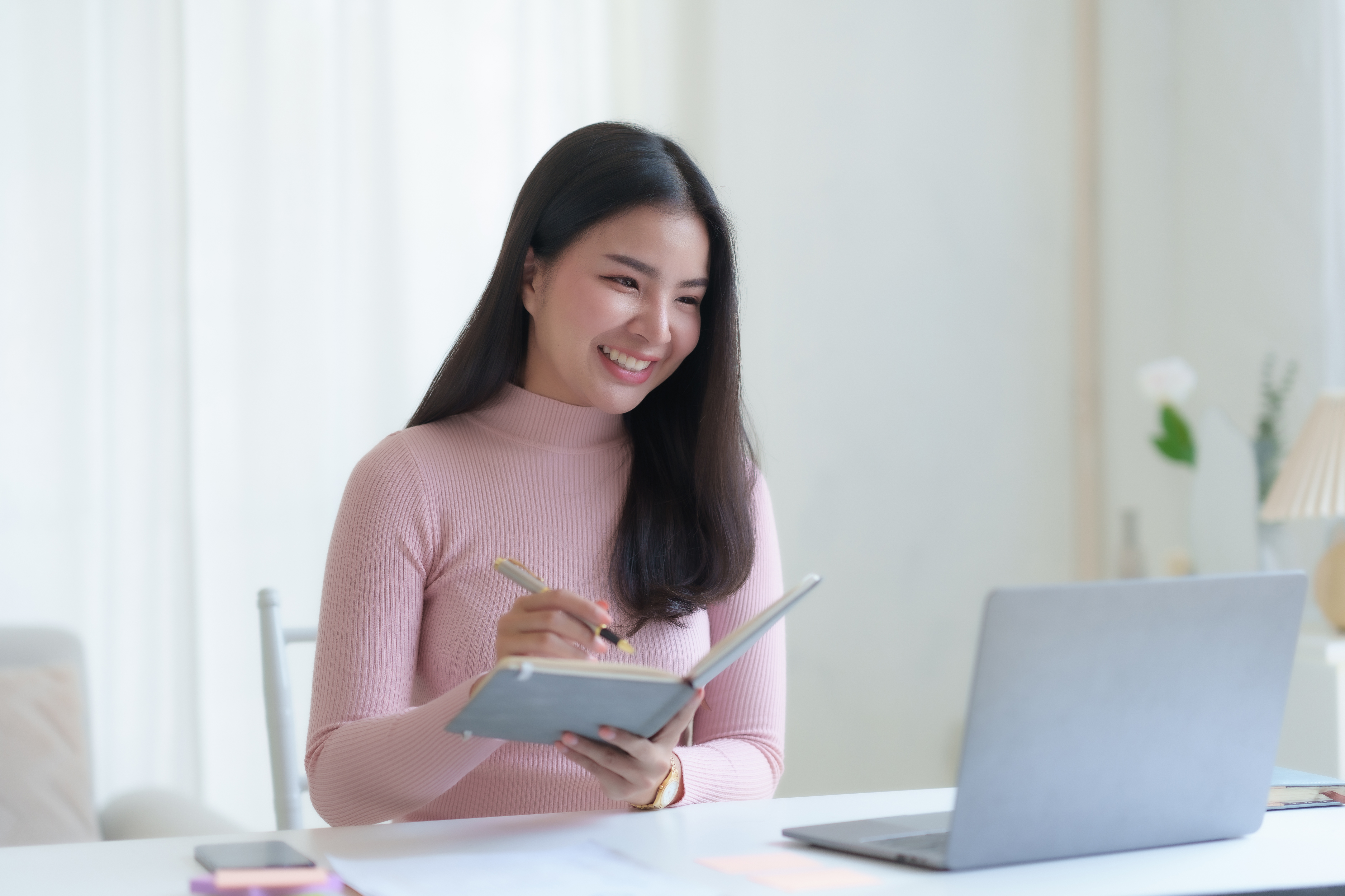 Smiling happy asian businesswoman sitting with laptop computer t