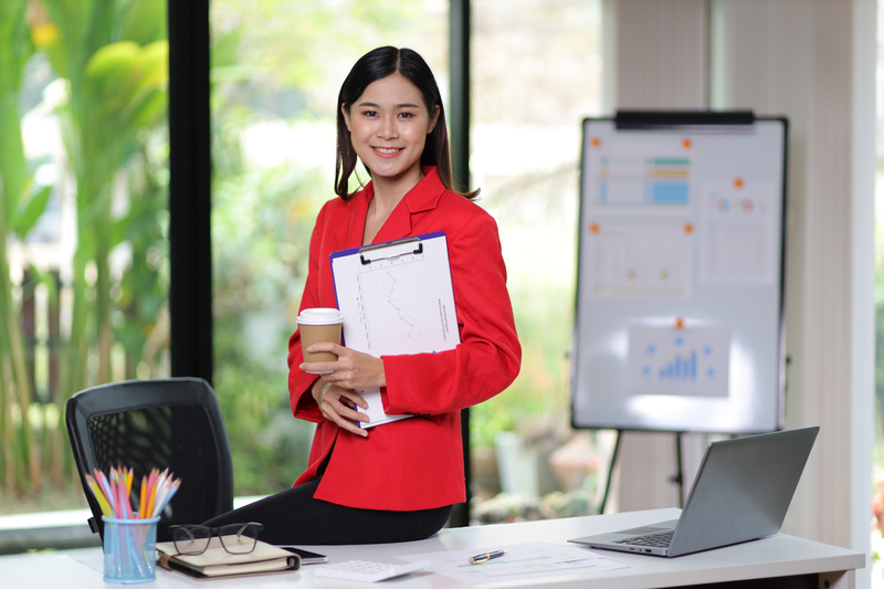Attractive asian business woman secretary portrait at office desk.